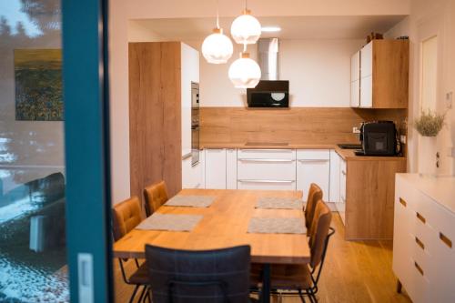 a kitchen with a wooden table and chairs at MOLO LIPNO RESIDENCE in Lipno nad Vltavou