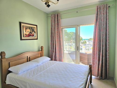 a bedroom with a bed and a large window at Sunny Beach Penthouse 271 in Lalzit Bay