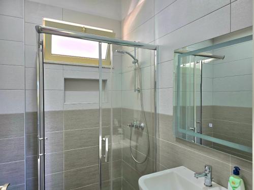 a bathroom with a shower and a sink and a mirror at Sunny Beach Penthouse 271 in Lalzit Bay
