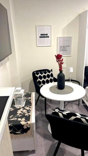 a living room with a white table and black chairs at Loreto Prestige - Parking Free & Bulb Gym in Milan