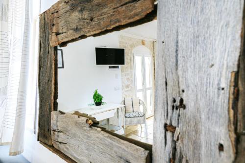a room with a table and a television on a wall at Le Dimore di Trulli Mandorlo con piscina esclusiva in Putignano