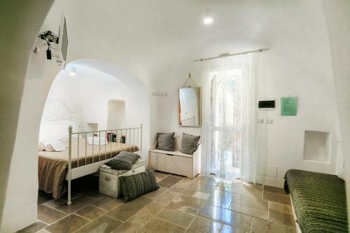 a white room with a bed and a window at Le Dimore di Trulli Mandorlo con piscina esclusiva in Putignano