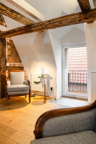 a living room with a chair and a window at Johannis Suite - Schrangen-Suites-1389 in Lüneburg