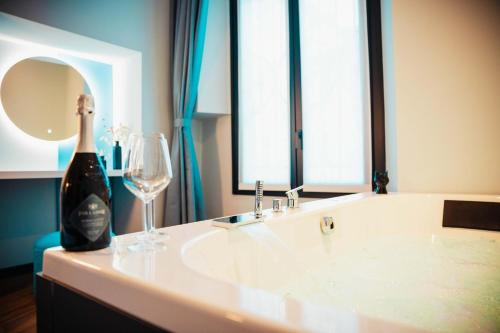 a bottle of wine and a wine glass on a counter at Penelope's Suite&Spa con parcheggio privato in Como