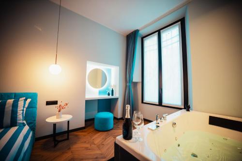 a bathroom with a tub and a large window at Penelope's Suite&Spa con parcheggio privato in Como