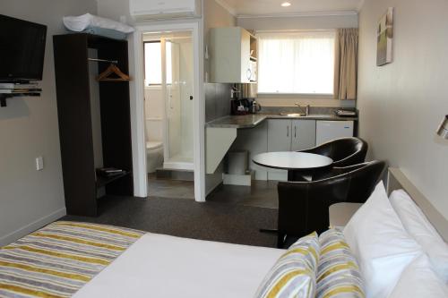 a hotel room with a bed and a kitchen at Quality Inn Acapulco Taupo in Taupo