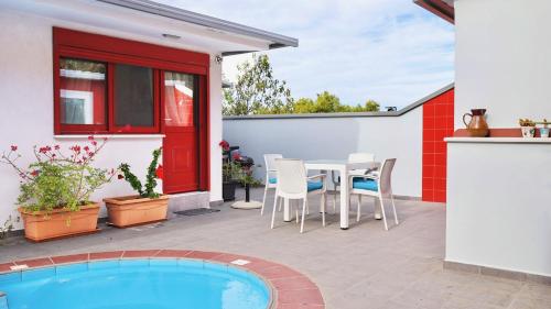 a patio with a table and chairs and a pool at The Bordeaux Door in Aegina Town