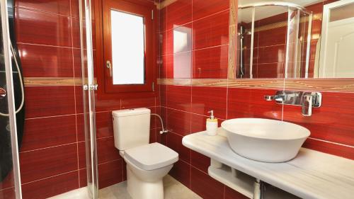 a bathroom with a toilet and a sink and a mirror at The Bordeaux Door in Aegina Town