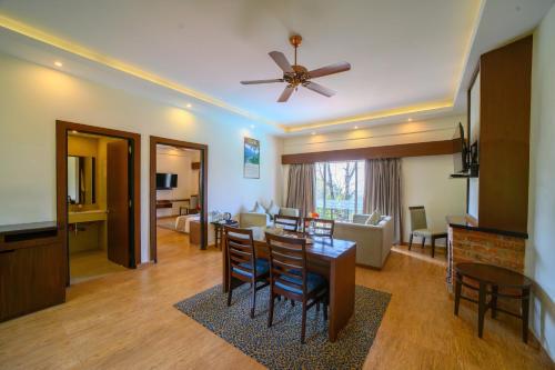 a living room with a ceiling fan and a dining room at Sinclairs Retreat Kalimpong in Kalimpong