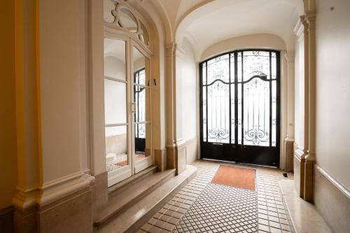 un couloir avec une porte noire et une fenêtre dans l'établissement Appartement neuf et luxueux climatisé à Paris 17, à Paris