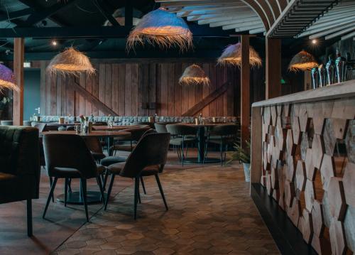 a restaurant with a bar with chairs and tables at Glamping De Boshoek in Voorthuizen