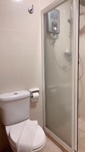 a bathroom with a toilet and a shower at 103 Hotel in Kuala Lumpur