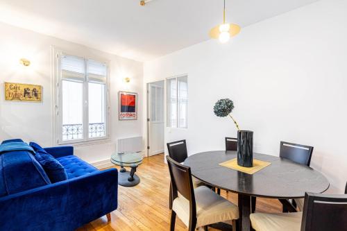 un salon avec une table et un canapé bleu dans l'établissement GuestReady - Parisian style home by la Bastille, à Paris