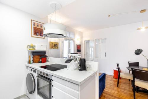 - une cuisine avec un comptoir blanc dans une pièce dans l'établissement GuestReady - Parisian style home by la Bastille, à Paris