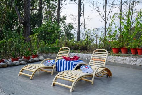 two chairs and a table with a striped table cloth at Sinclairs Retreat Kalimpong in Kalimpong