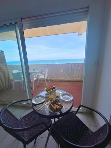 d'une table et de chaises avec une assiette de nourriture sur un balcon dans l'établissement Studio vue mer bord de plage, à San-Nicolao