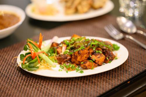 a white plate of food on a table at Sinclairs Retreat Kalimpong in Kalimpong