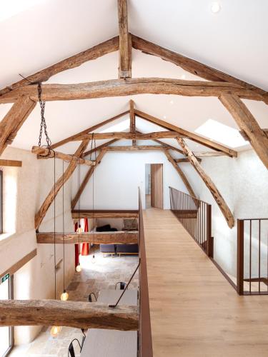 a large room with wooden beams and a staircase at Laborde in Monpardiac