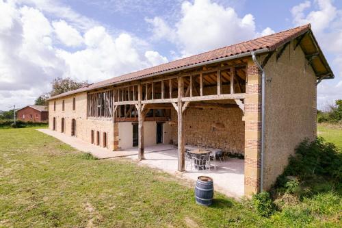 a large brick building with a picnic table outside at Laborde in Monpardiac