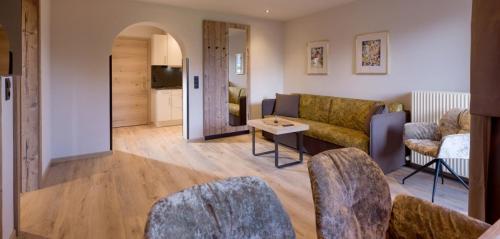 a living room with a couch and a table at Aparthotel Bergland in Söll