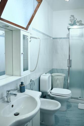 a white bathroom with a toilet and a sink at ORAMA apartment Front sea in Giardini Naxos