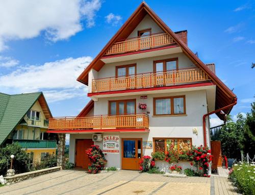 a house with a gambrel roof at Pokoje Gościnne Janina Bocheńczak in Gliczarów