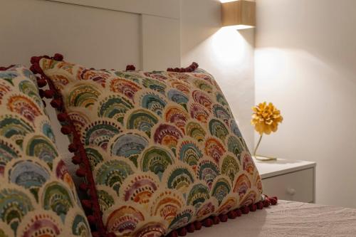 a pillow sitting on a bed next to a lamp at Vivienda Turística CASA QUEVEDO in Úbeda