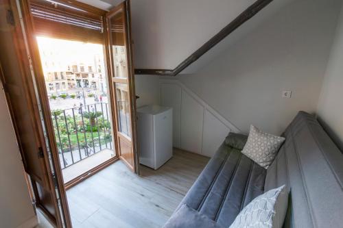 a living room with a couch and a large window at Vivienda Turística CASA QUEVEDO in Úbeda