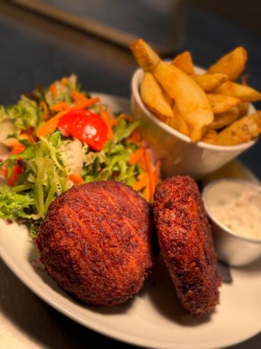 a plate of food with two meatballs and french fries at The Fishmongers Tavern in Sheringham