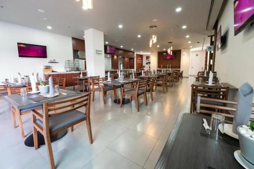 a dining room with wooden tables and chairs at Holiday Inn Uruapan by IHG in Uruapan del Progreso