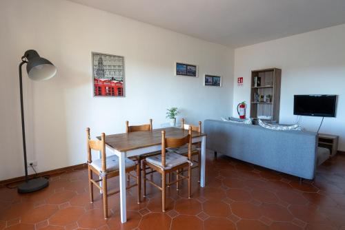 a dining room with a table and a couch at Da Nonna Gina, casa luminosa con aria condizionata in Viareggio