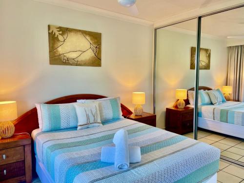 a bedroom with two beds and two lamps at Poinciana 106 in Hamilton Island