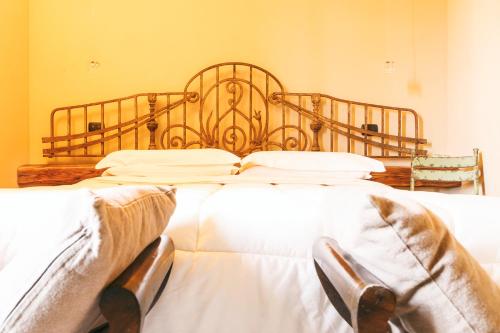 a bedroom with a large bed with white sheets at L'Orto Di Panza in Abbadia di Montepulciano