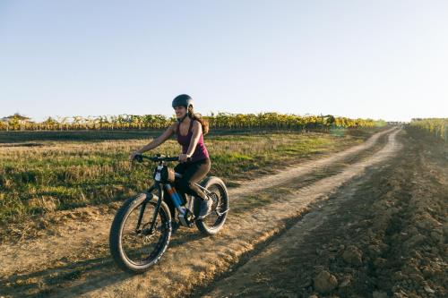 a woman riding a bike on a dirt road at L'Orto Di Panza in Abbadia di Montepulciano