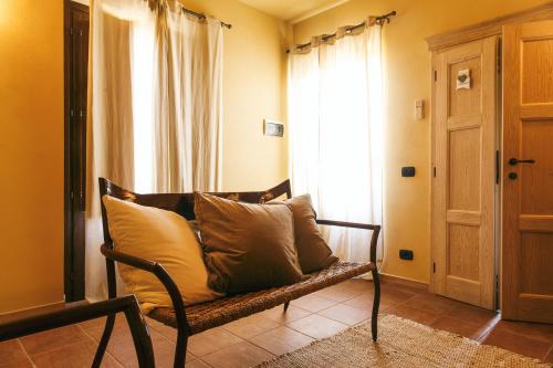 a couch with pillows sitting in a room with a window at L'Orto Di Panza in Abbadia di Montepulciano
