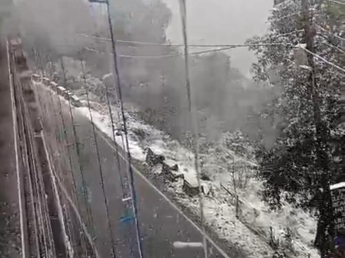 a view of a snow covered road with a fence at Sleeping Beauty Hotel Moutain view property in Joshīmath