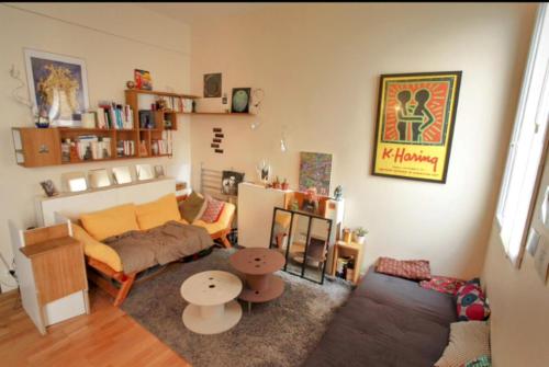 un salon avec un canapé et une table dans l'établissement Sweet little flat in Montmartre, à Paris