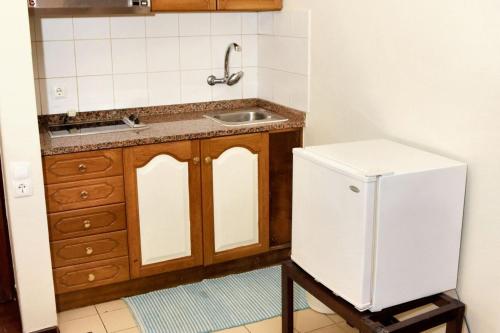 una cucina con un lavello e un frigorifero bianco di Charming studio in Funchal, 30m², city view a Funchal