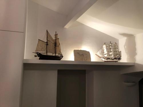 a shelf with a toy boat and a model ship at La Léinade in Île dʼAix