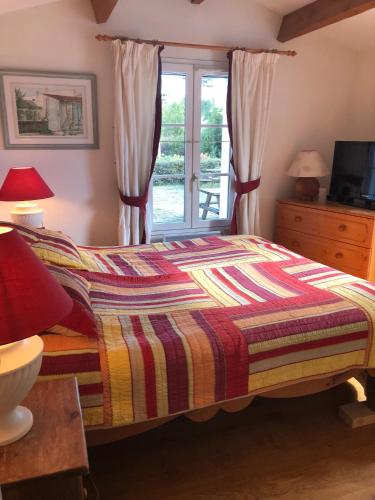a bedroom with a bed and a window at La Léinade in Île dʼAix