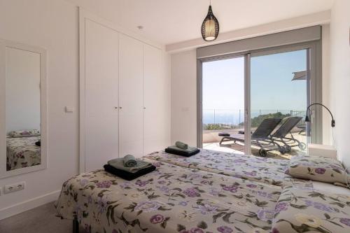 a bedroom with a bed and a large window at Seaview 3-bed Flat With 2 Terraces Mijas Pueblo in Mijas