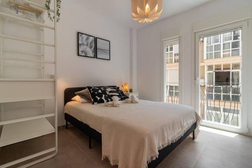 a bedroom with a bed and a large window at Charming Apartment in the Heart of Málaga in Málaga