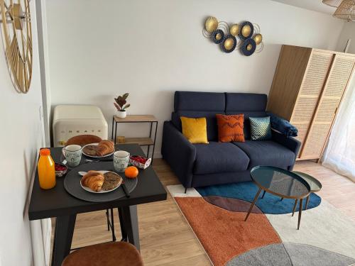 un salon avec une table avec de la nourriture dessus dans l'établissement Furnished studio Paris 17, à Paris