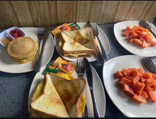 een tafel met drie borden toast en wortelen bij Wadon Menjangan homestay in Banyuwedang