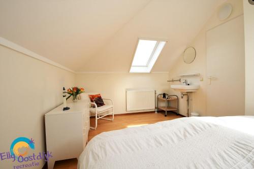 a bedroom with a bed and a sink and a window at Westduin 6 - Elly Oostdijk Recreatie - Vakantiehuis Vlissingen in Vlissingen