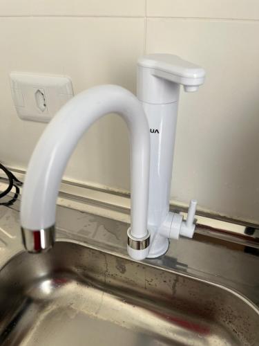 eine Küchenspüle mit einem weißen Wasserhahn in der Unterkunft Aconchegante Apto Carapicuiba in Carapicuíba