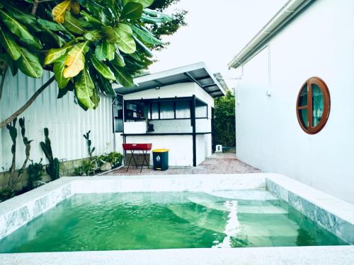 une piscine d'eau à côté d'un bâtiment blanc dans l'établissement Love koh tao villa, à Koh Tao