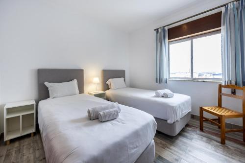 T3 Moinho by Seewest في Santo Amaro: غرفة فندق بها سريران ونافذة