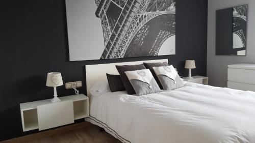 una camera con un letto bianco con due comodini di Residencial Torres Roma a Tarragona