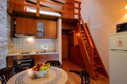 a kitchen with a table with a bowl of fruit on it at Malvazija i Teran in Buje